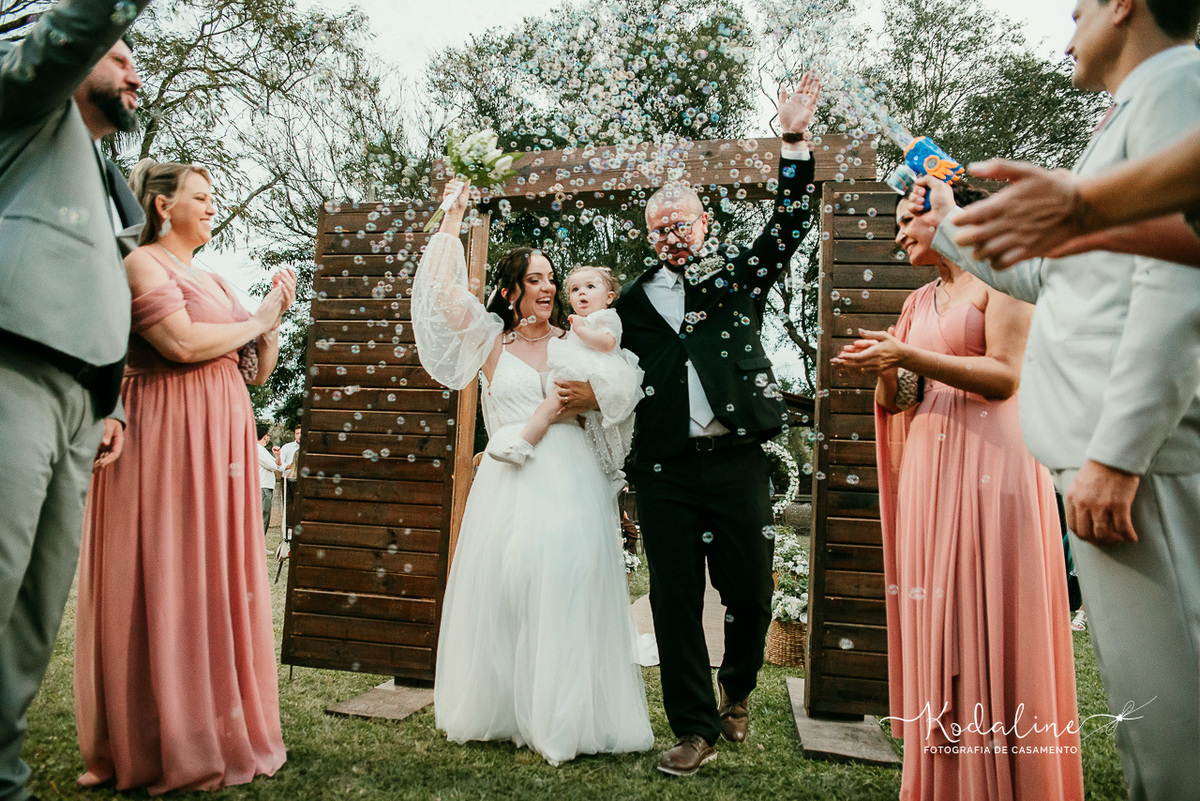 Noivos celebrando o casamento cercados pelos quatro filhos e por toda a família