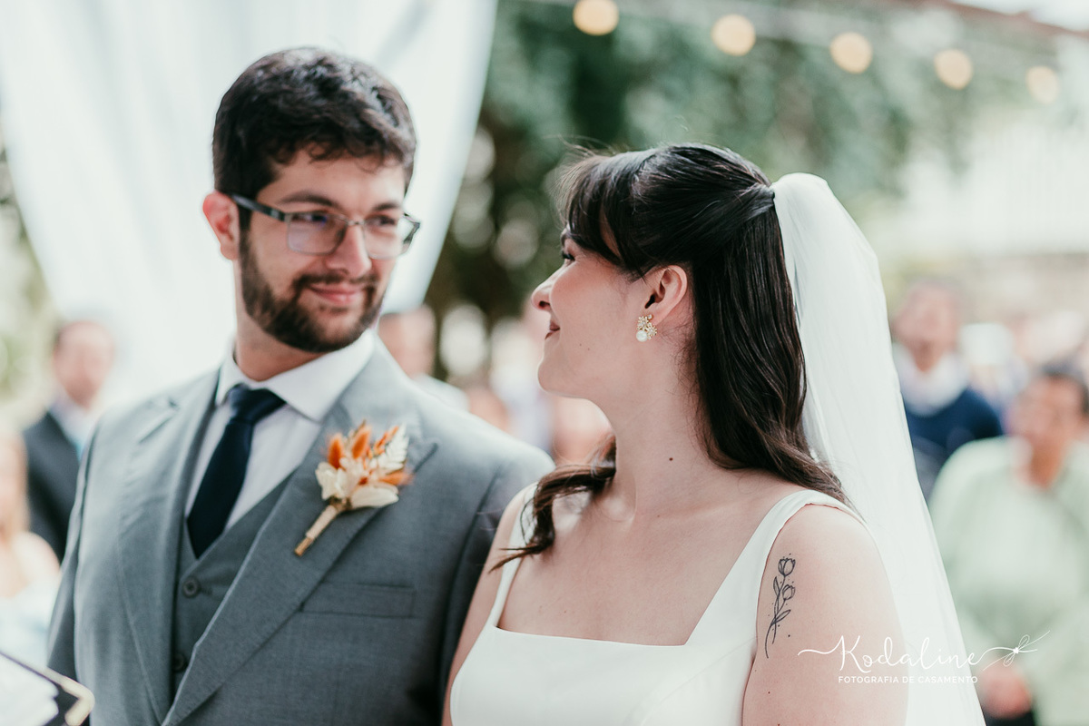 Noivos trocando olhares durante a cerimônia de casamento.