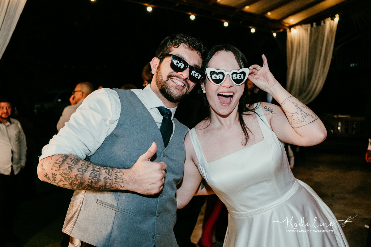 Noivos aproveitando a festa de casamento ao lado dos convidados.