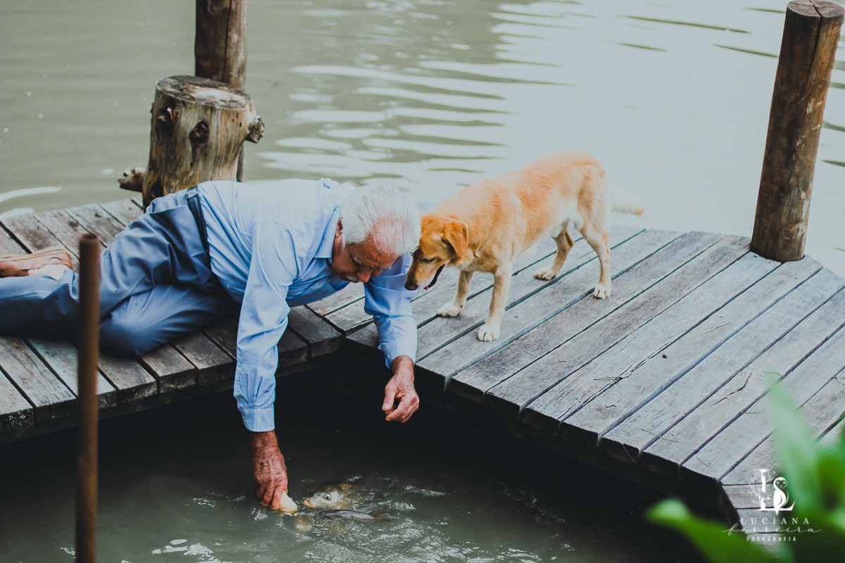 Senhor e cachorro alimentando peixes