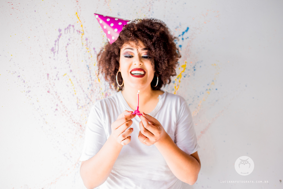 Ensaio Feminino. Mulher com chapéu de festa e vela de aniversário