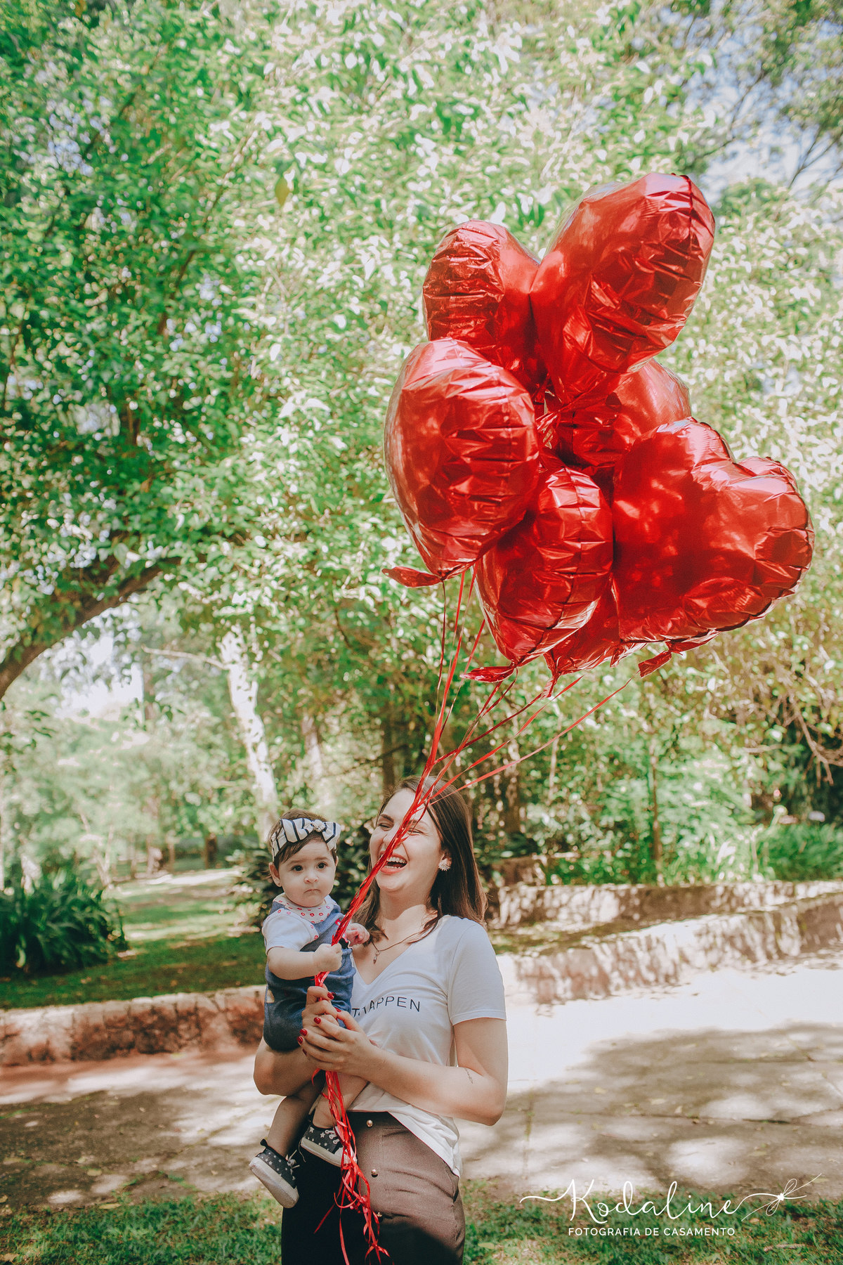 Noiva com criança segurando balões de coração