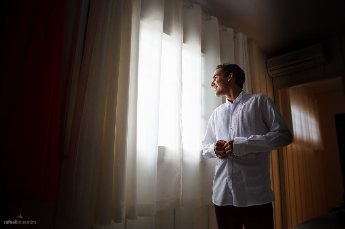 o noivo com seu olhar pela janela, um pouco nervoso, pois, estava na casa de um padrinho muito querido para ele.