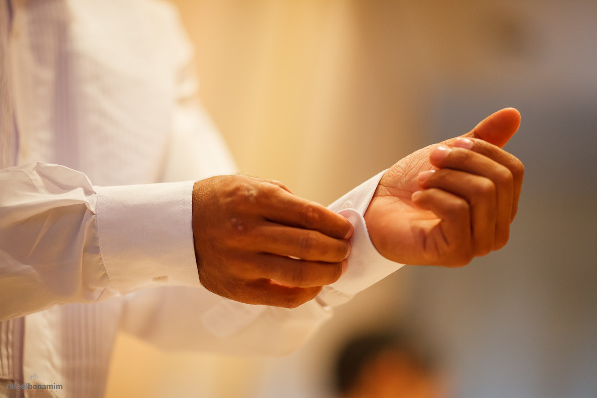 com poucos detalhes, a fotografia do noivo arrumando a camiseta.