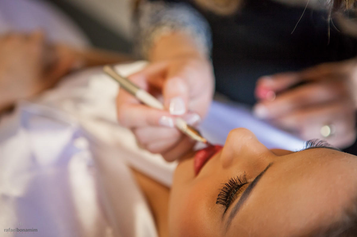 detalhes na aplicação do baton aos lábios, making of perfeito, cor de batom vermelho.