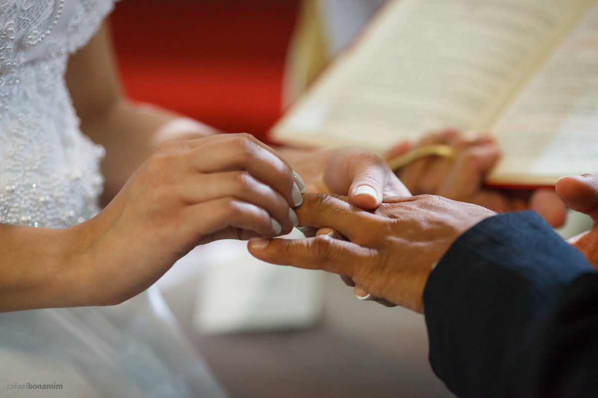 a Noiva Cássia colocando a aliança em seu noivo Ernesto.
