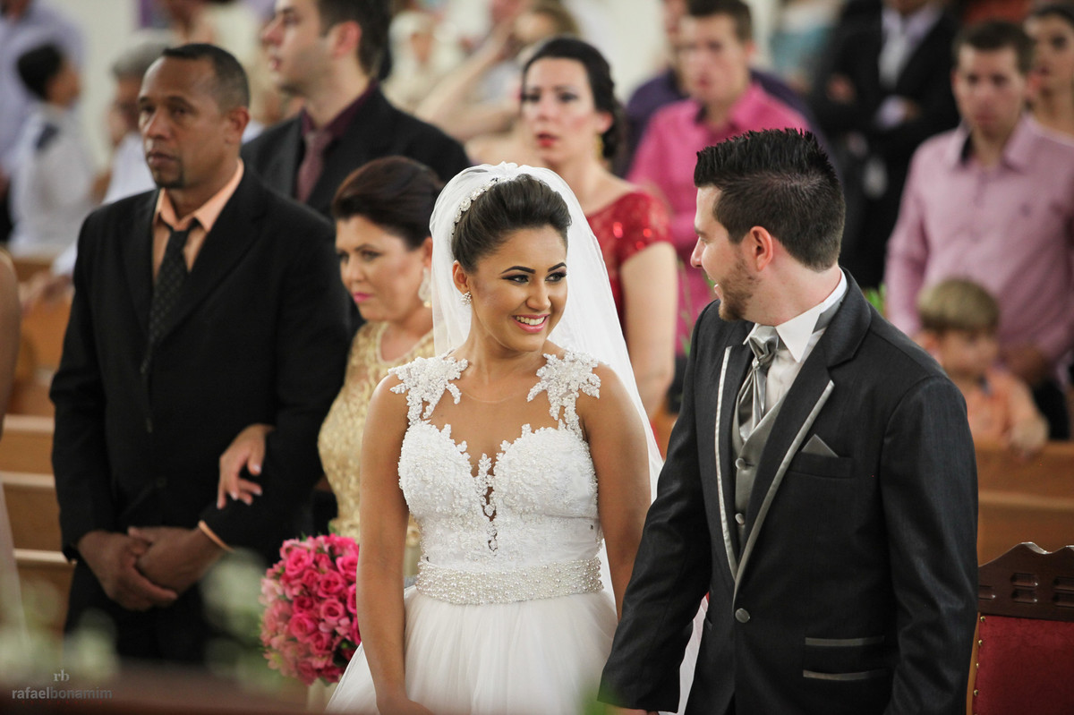 noiva Andréia sorrindo no altar para seu futuro esposo.