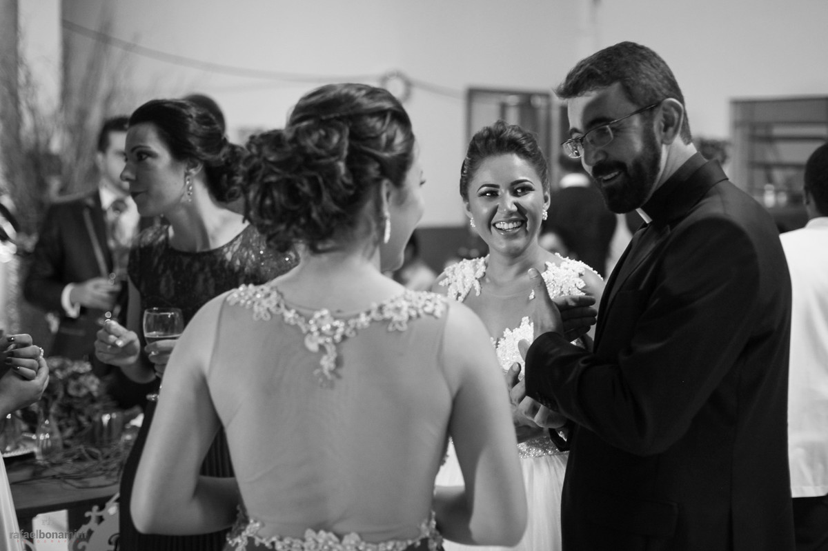 noiva contando com o padre na festa do casamento