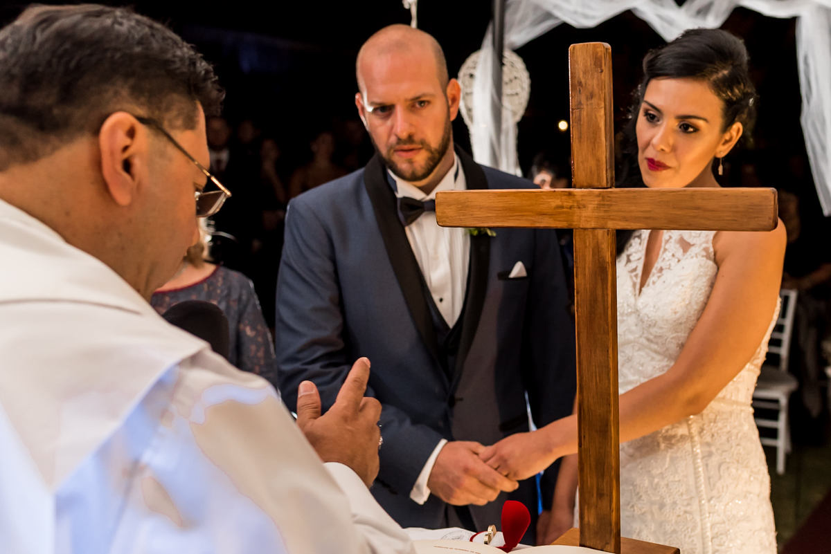 cruz, novios en el altar frente a una cruz, vestido blanco con perla, traje con moño, fotografo de bodas. casamiento en tara multievento, fotogrago para casamiento
