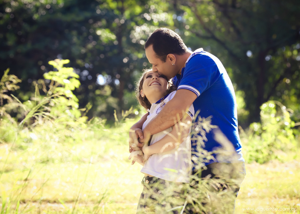 jaque risse, andre risse, estudio bebedouro, melhores fotografos,  noivo abraçando sua noiva, e beijando sua testa, noiva  o olhando e sorrindo, plantas em  volta deles