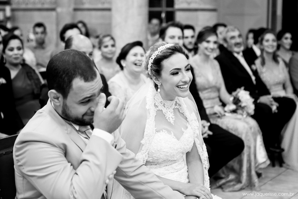 jaque risse, andre risse, estudio bebedouro, melhores fotografos, noivos sentados no altar, sorrindo, convidados de fundo rindo