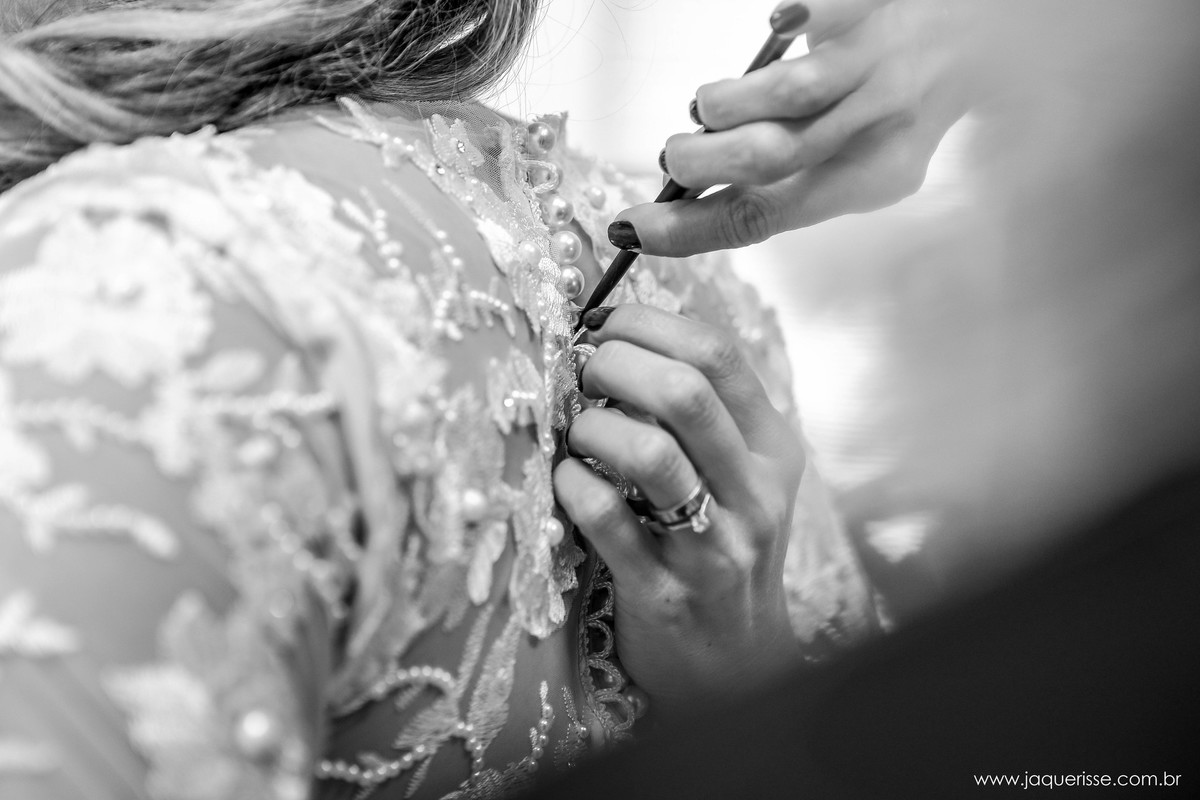 jaque risse, andre risse, estudio bebedouro, melhores fotografos, detalhe do vestido da noiva sendo abotoado com o auxilio de um cabo de pente de cabelo durante o making of
