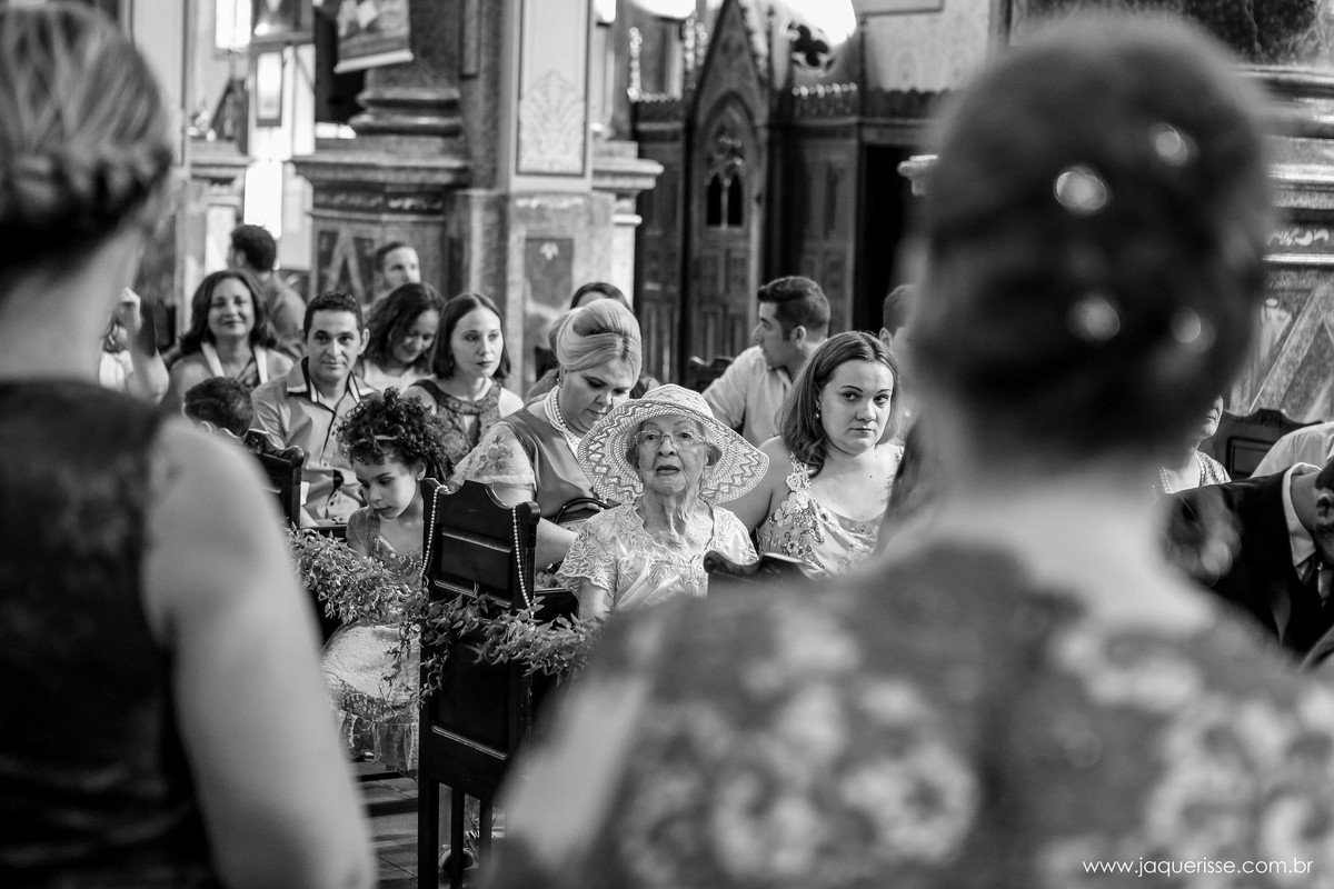 jaque risse, andre risse, estudio bebedouro, melhores fotografos, varias pessoas sentadas nos bancos da igreja com foco na senhora com chapéu