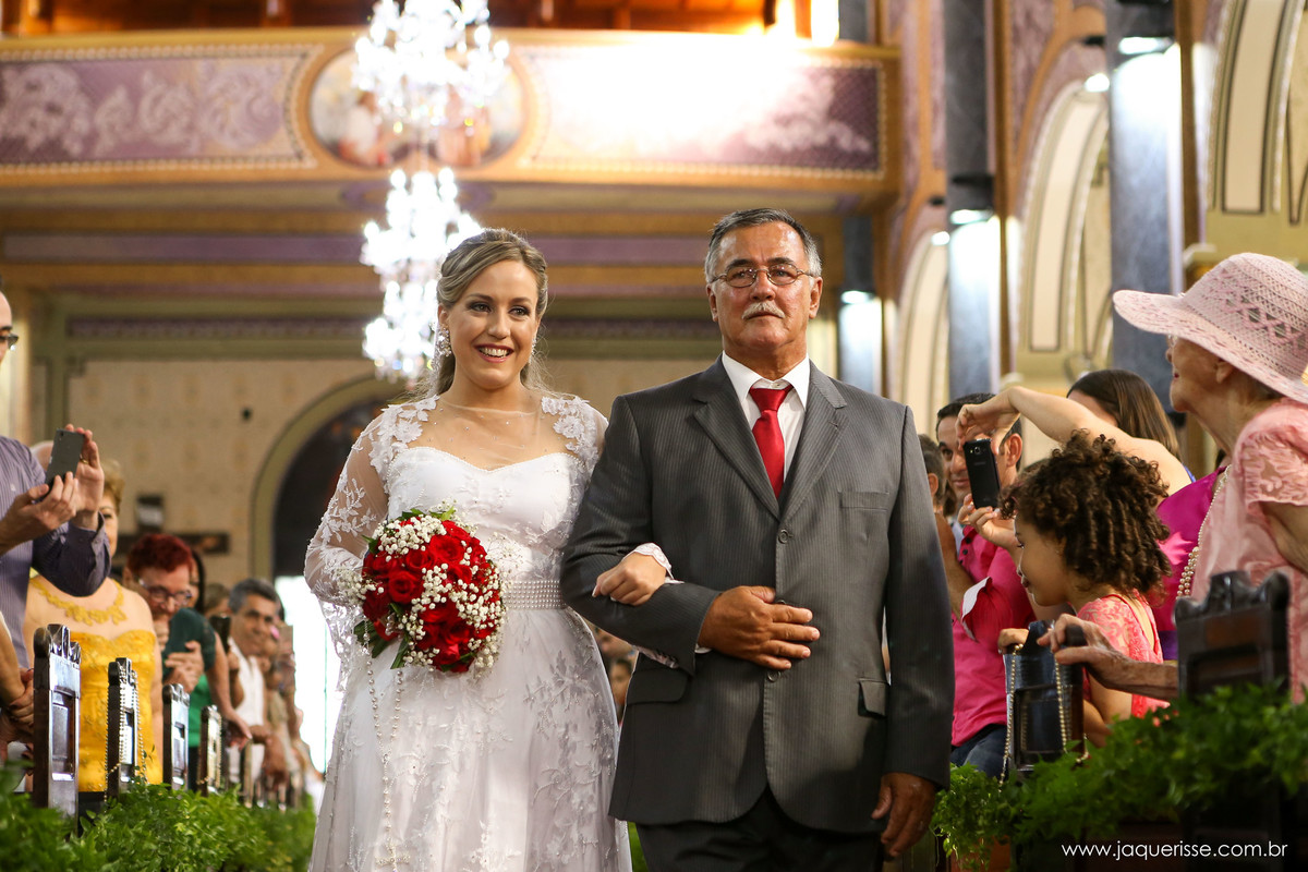 jaque risse, andre risse, estudio bebedouro, melhores fotografos, noiva com um lindo sorriso entrando na igreja com seu pai