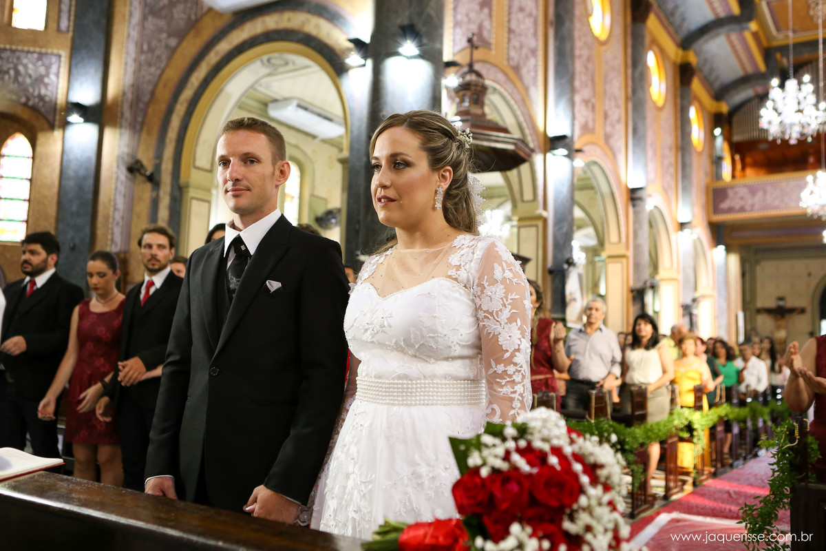 jaque risse, andre risse, estudio bebedouro, melhores fotografos, noiva e noivo em pés em frente ao genuflexório com os convidados assistindo a cerimonia