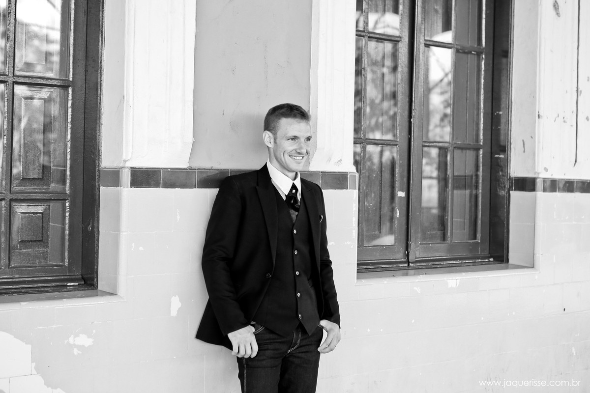jaque risse, andre risse, estudio bebedouro, melhores fotografos, noivo posando para foto encostado na parede de uma antiga estação de trem próximo a uma janela