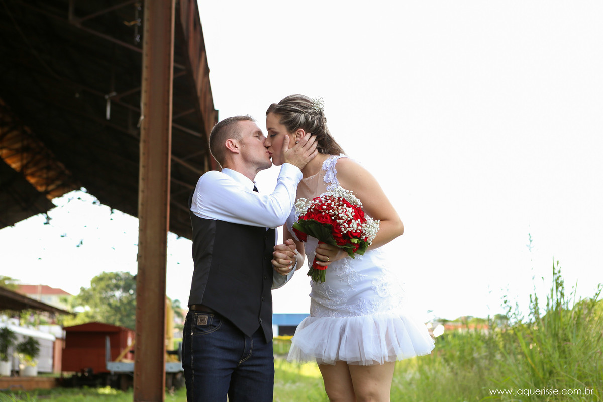 jaque risse, andre risse, estudio bebedouro, melhores fotografos, beijo romântico entre os noivos com a estação de trem antiga ao fundo