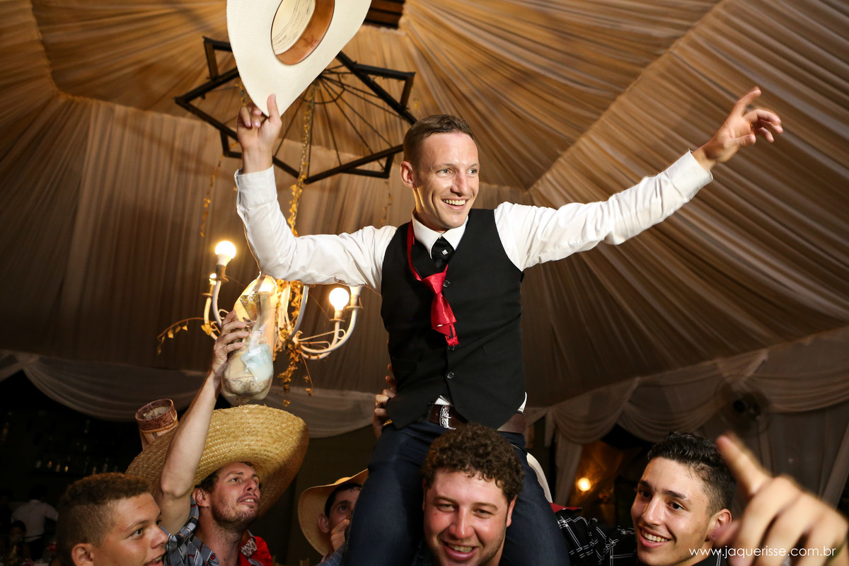 jaque risse, andre risse, estudio bebedouro, melhores fotografos, noivo sorridente segurando o chapéu em uma de suas mãos sendo carregado no ombro dos amigos num momento de grande descontração