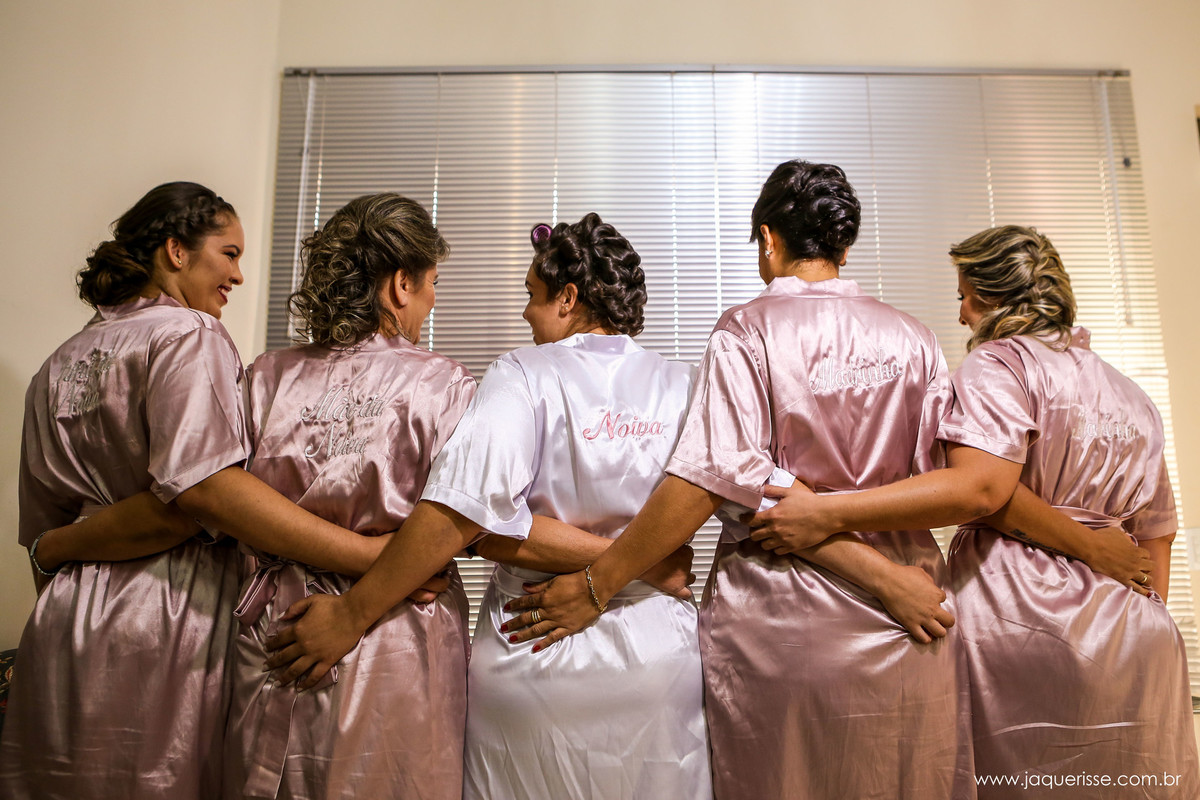 madrinhas, noiva e mãe da noiva abraçadas de costas para a foto mostrando seus robes no click da fotógrafa de casamento Bebedouro SP Jaque Risse