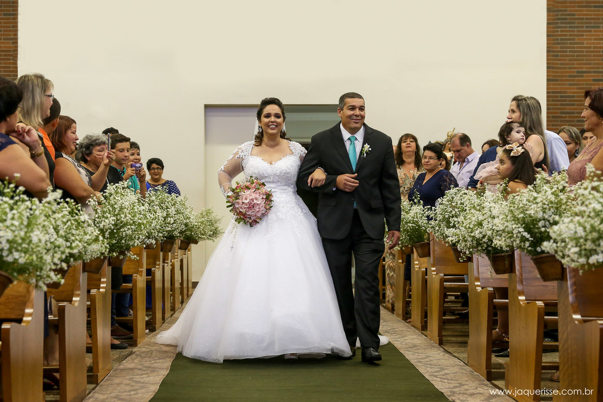 entrada da noiva na igreja de braços dados com seu pai ambos sorridentes no click da fotógrafa de casamento Bebedouro SP Jaque Risse