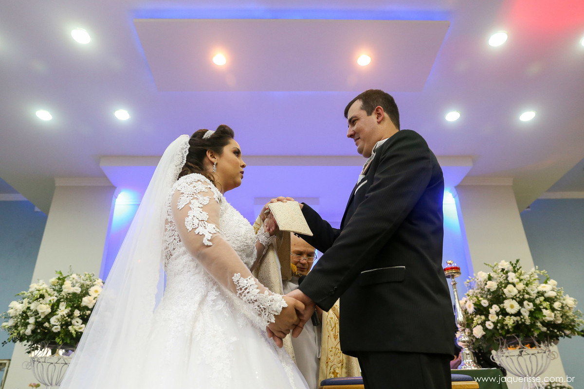 noivo e noiva de frente um para o outro sendo abençoados pelo padre no click da fotógrafa de casamento Bebedouro SP Jaque Risse