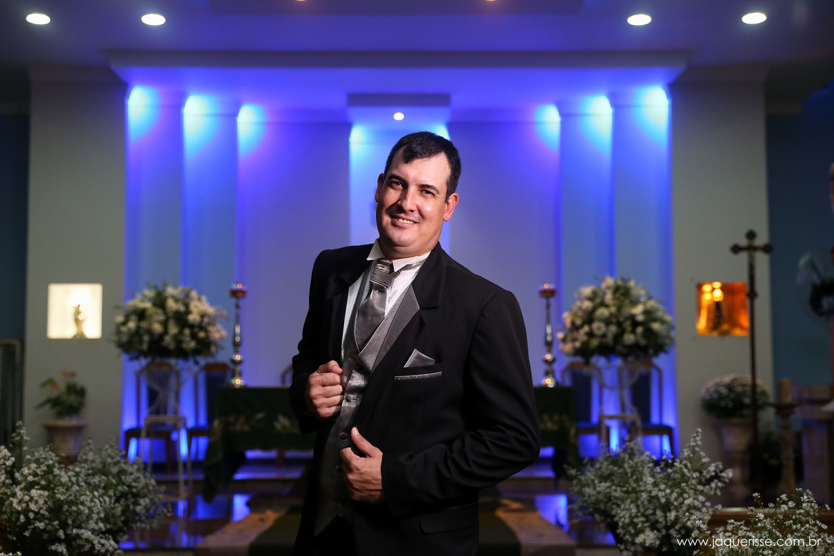 noivo sorridente posando para foto dentro da igreja com a iluminação reduzida no click da fotógrafa de casamento Bebedouro SP Jaque Risse