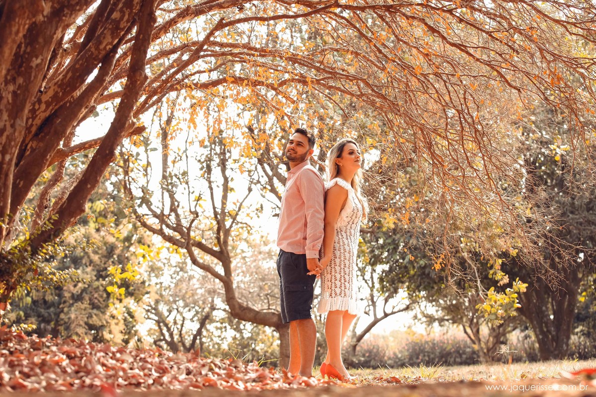 casal de noivos posando embaixo de uma jabuticabeira com folhas secas espalhadas pelo chão na cena do Pre wedding ou ensaio externo clicado pela fotografo de casamento jaque risse em bebedouro sp
