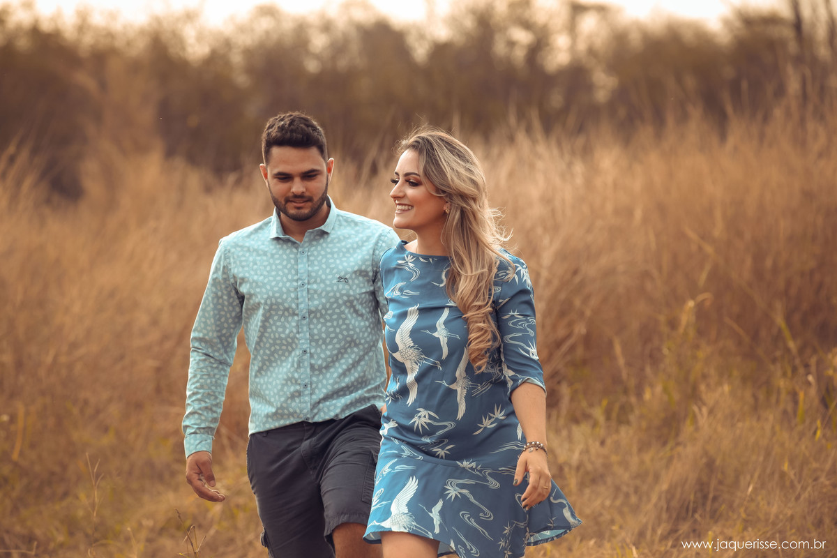 casal de noivos andando pela vegetação seca 
 na cena do Pre wedding clicado pela fotografo de casamento jaque risse em bebedouro sp