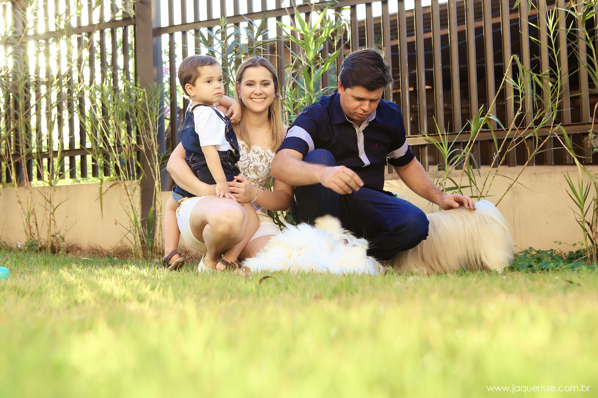 jaque risse, andre risse, estudio bebedouro, melhores fotografos, noiva olhando para frente e sorrindo, seu filho sentado de costas em seu colo, noivo brincando com os cahorros