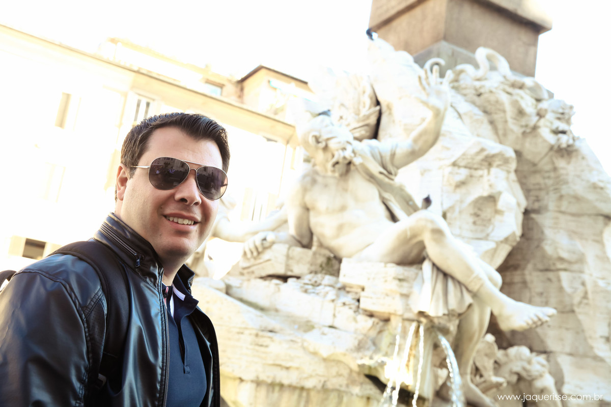 jaque risse, andre risse, estudio bebedouro, melhores fotografos, noivo de oculos de sol olhando e sorrindo, ao lado de uma estatua