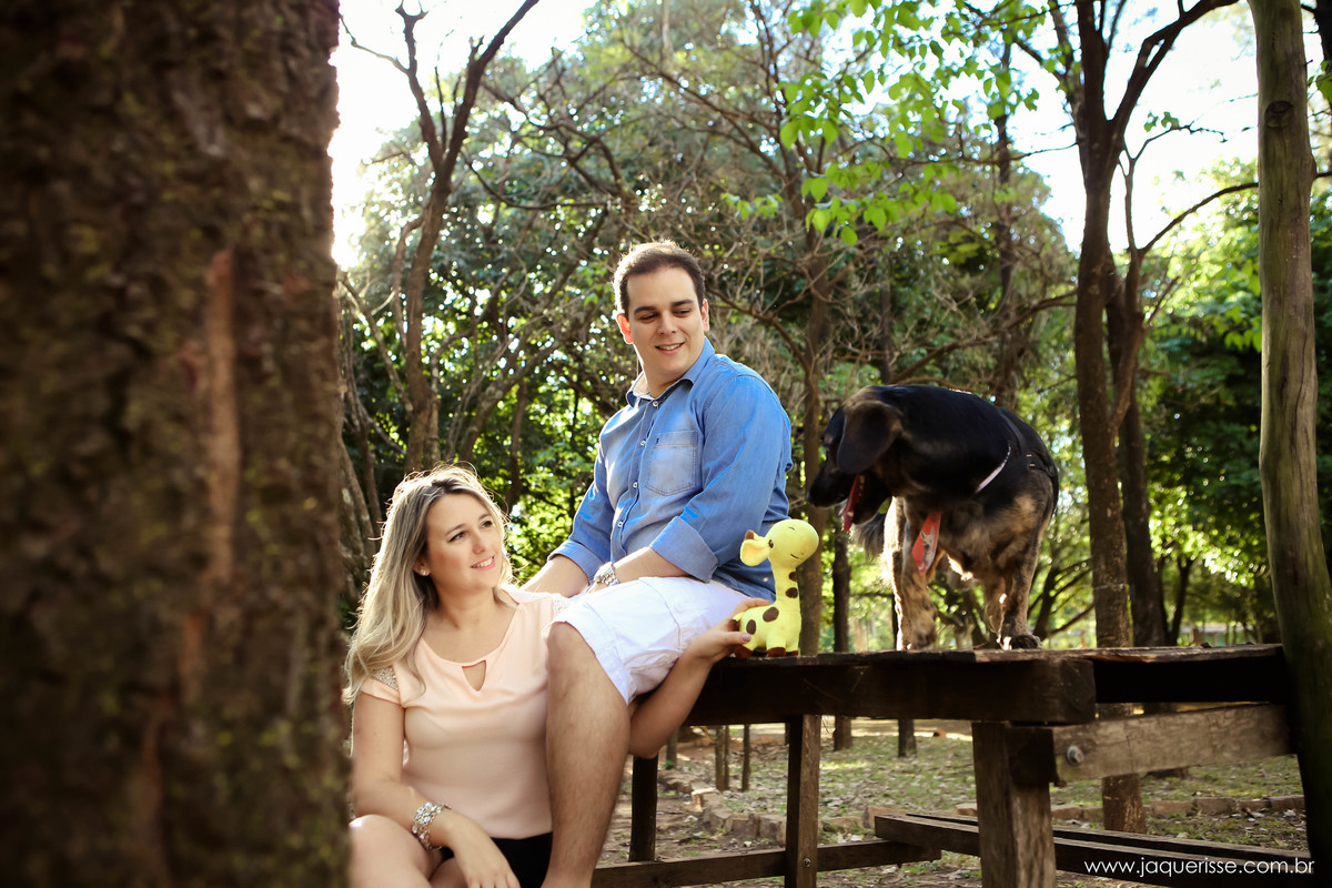 jaque risse, andre risse, estudio bebedouro, melhores fotografos, noivo sentado na madeira, noiva sentada em baixo, ambos olhando o cachorro com seu brinquedo