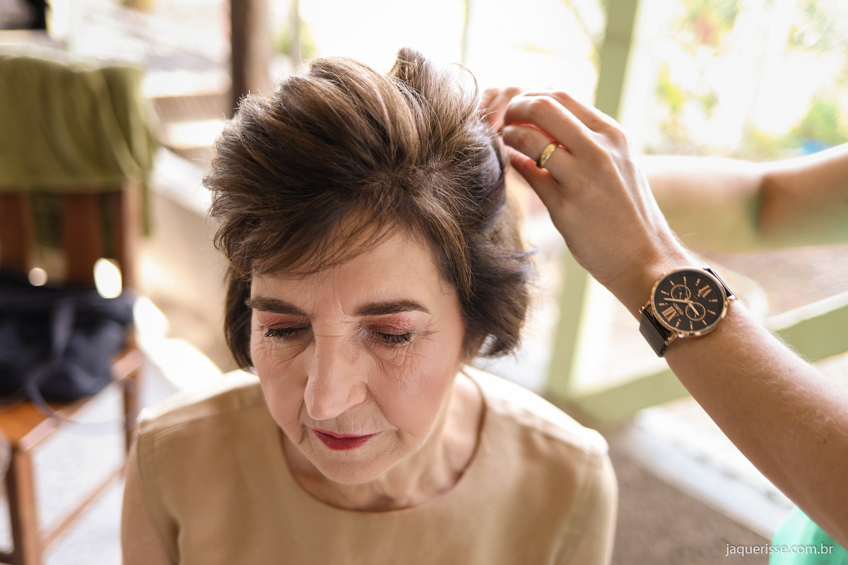 cabeleireira finalizando o penteado da noiva no making off da bodas de ouro registrado pelas lentes da fotografo de casamento jaque risse 