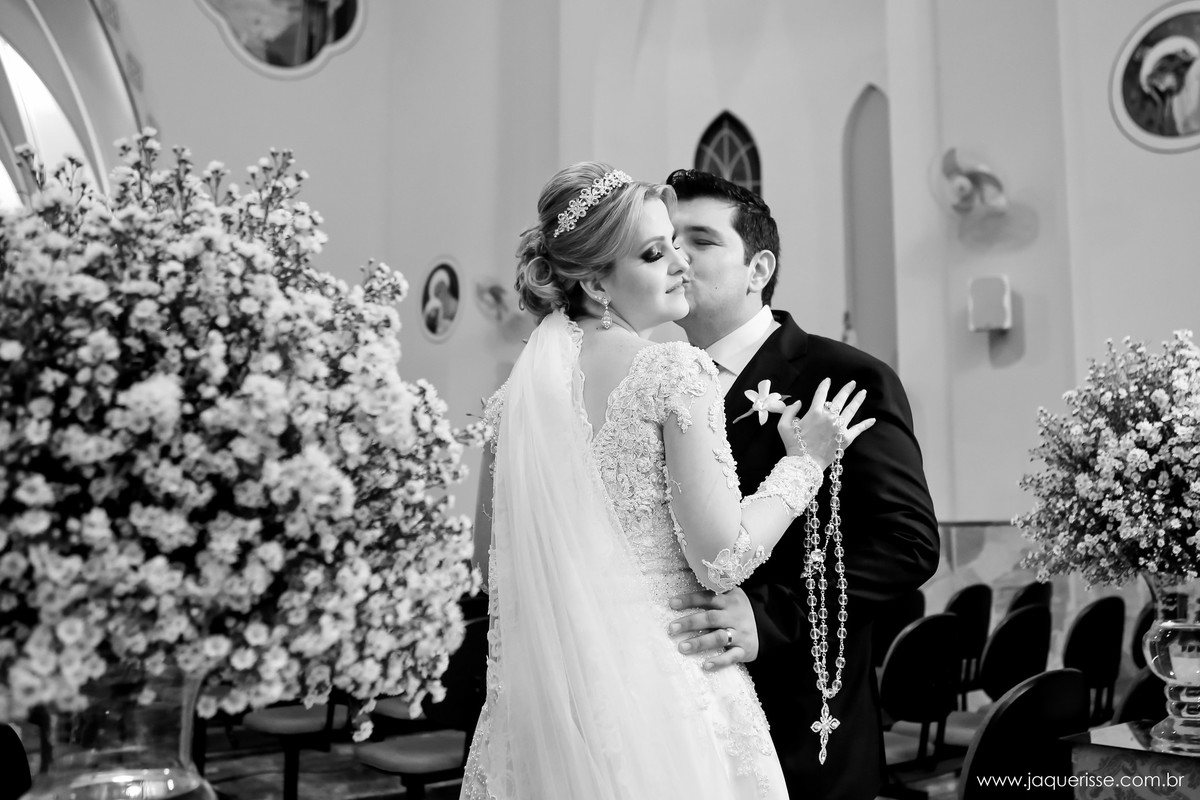 jaque risse, andre risse, estudio bebedouro, melhores fotografos, noivo beijando a bochecha da noiva, noiva apoiando sua mao ao peito do noivo e segurando o terço