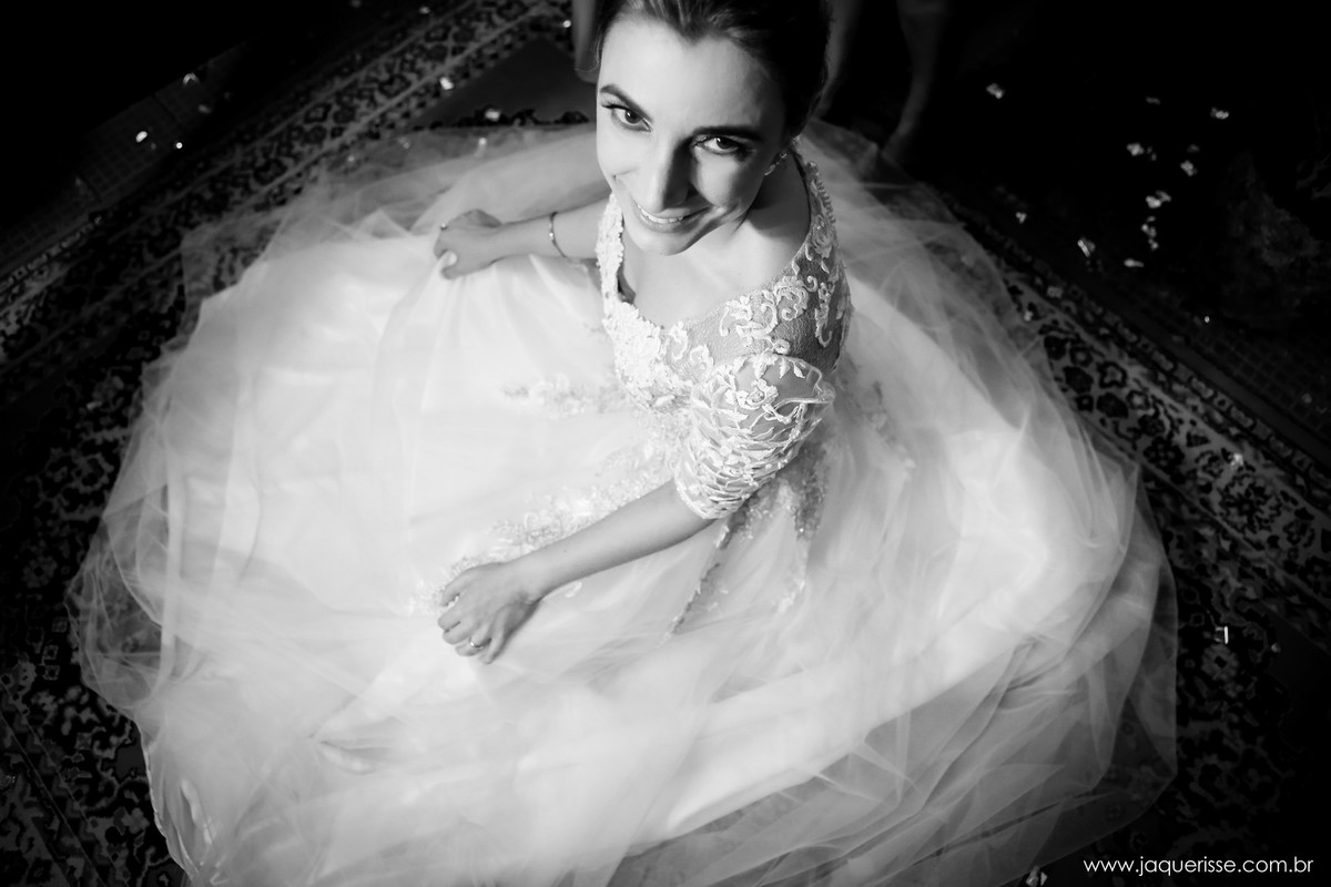 jaque risse, andre risse, estudio bebedouro, melhores fotografos, noiva sentada no chao com seu vestido aberto, olhando e sorrindo