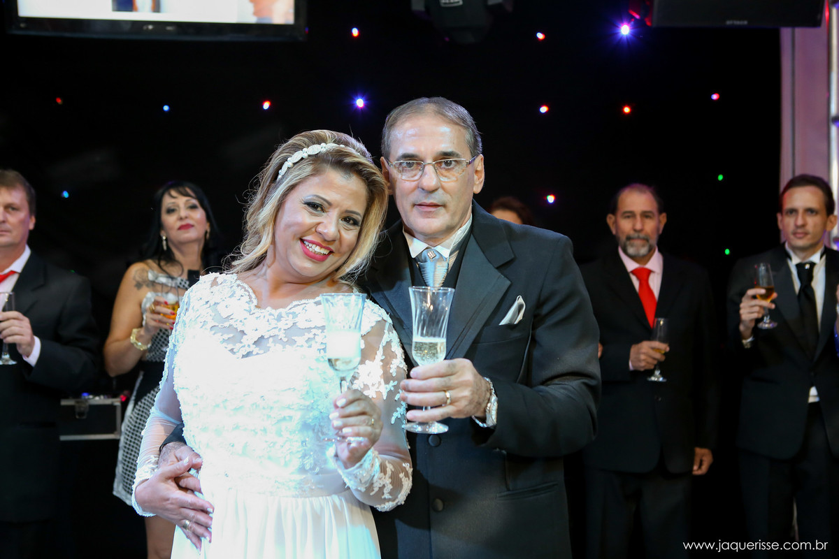 jaque risse, andre risse, estudio bebedouro, melhores fotografos, noivo abraçando sua noiva por traz, e os dois segurando suas taças para o brinde