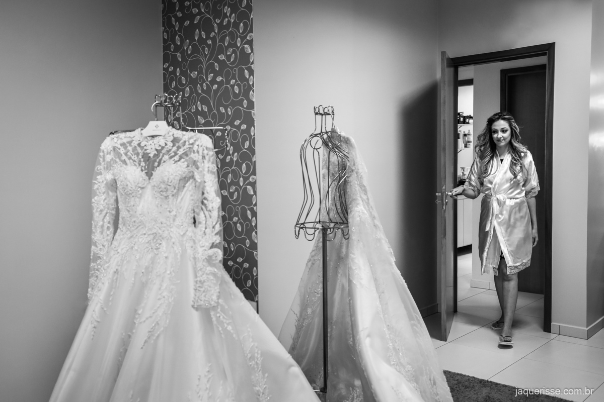 noiva de roupão abrindo a porta indo em direção ao vestido durante seção fotográfica do making of, fotografado pela jaque risse fotografia em bebedouro - sp