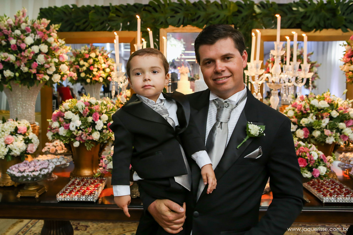 jaque risse, andre risse, estudio bebedouro, melhores fotografos, noivo segurando seu filho sorrindo, ambos de terno e decoraçao do fundo