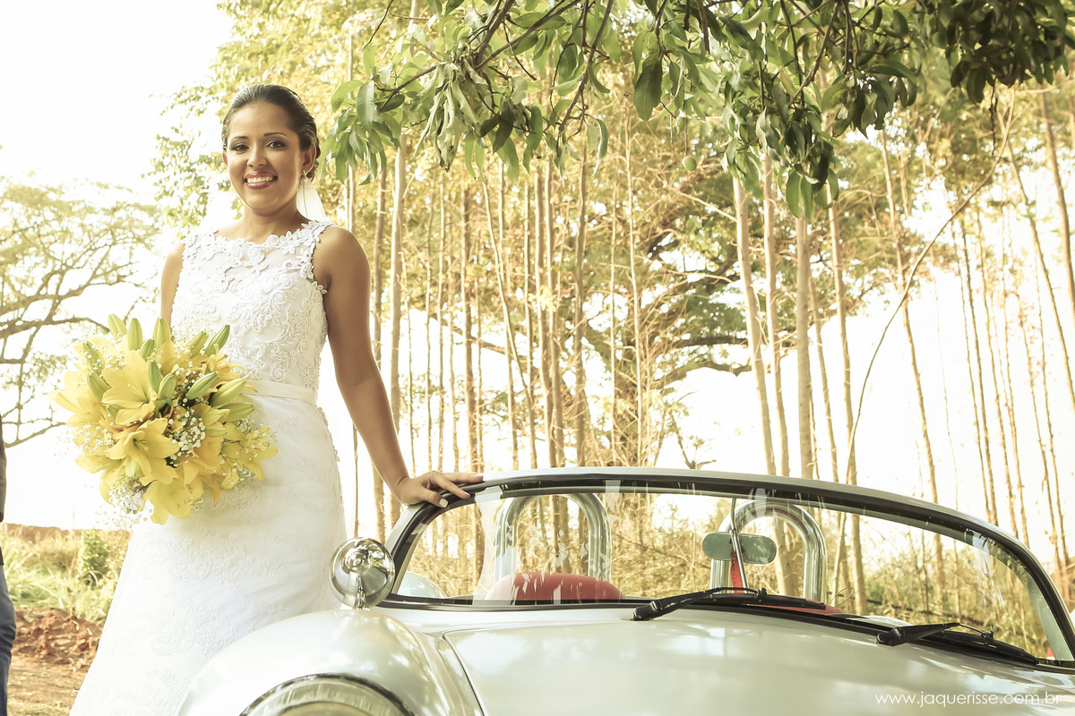 jaque risse, andre risse, estudio bebedouro, melhores fotografos, noiva em pe se apoiando no carro, sorrindo e segurando seu buque