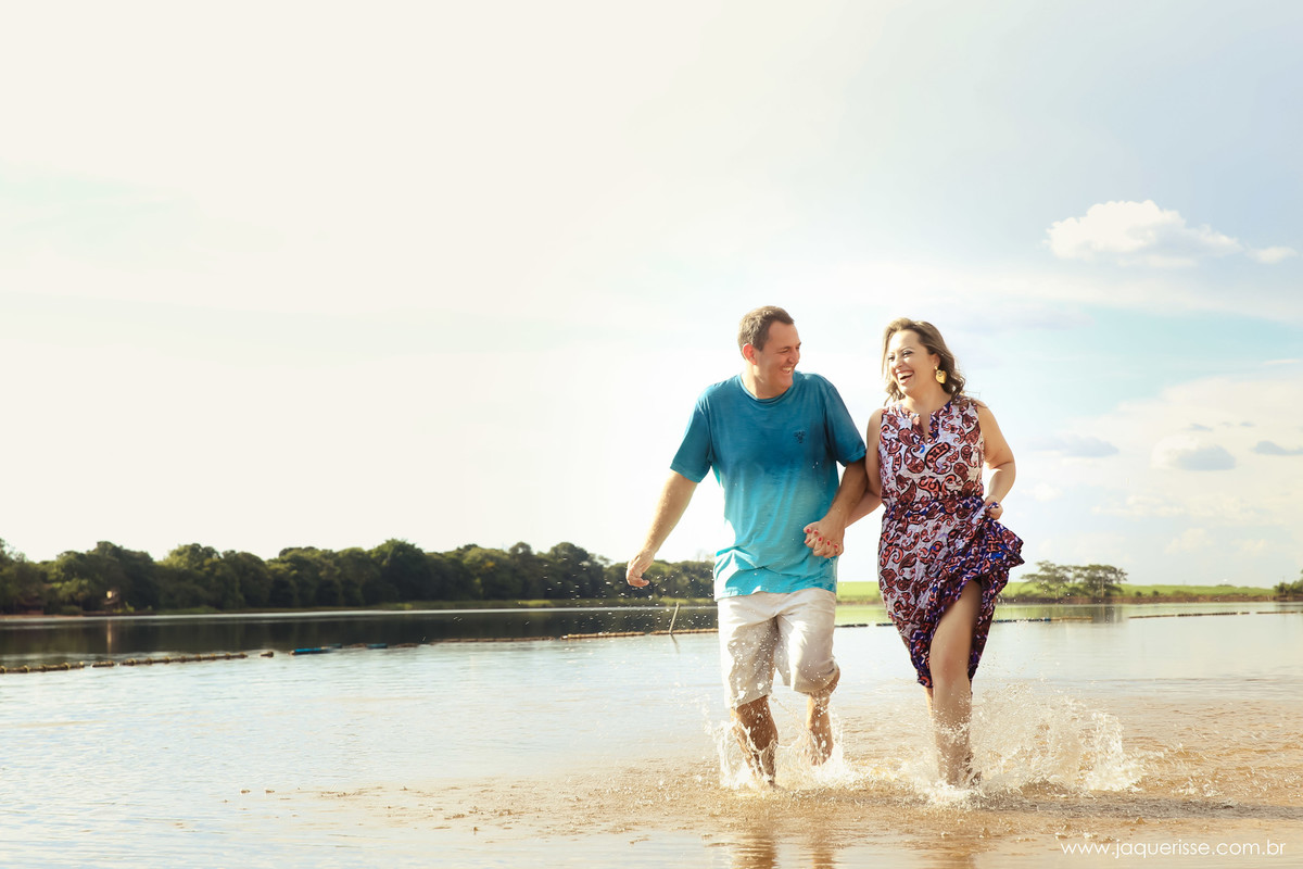 jaque risse, andre risse, estudio bebedouro, melhores fotografos, noivos andando no rio, sorridentes e uma mata ao fundo