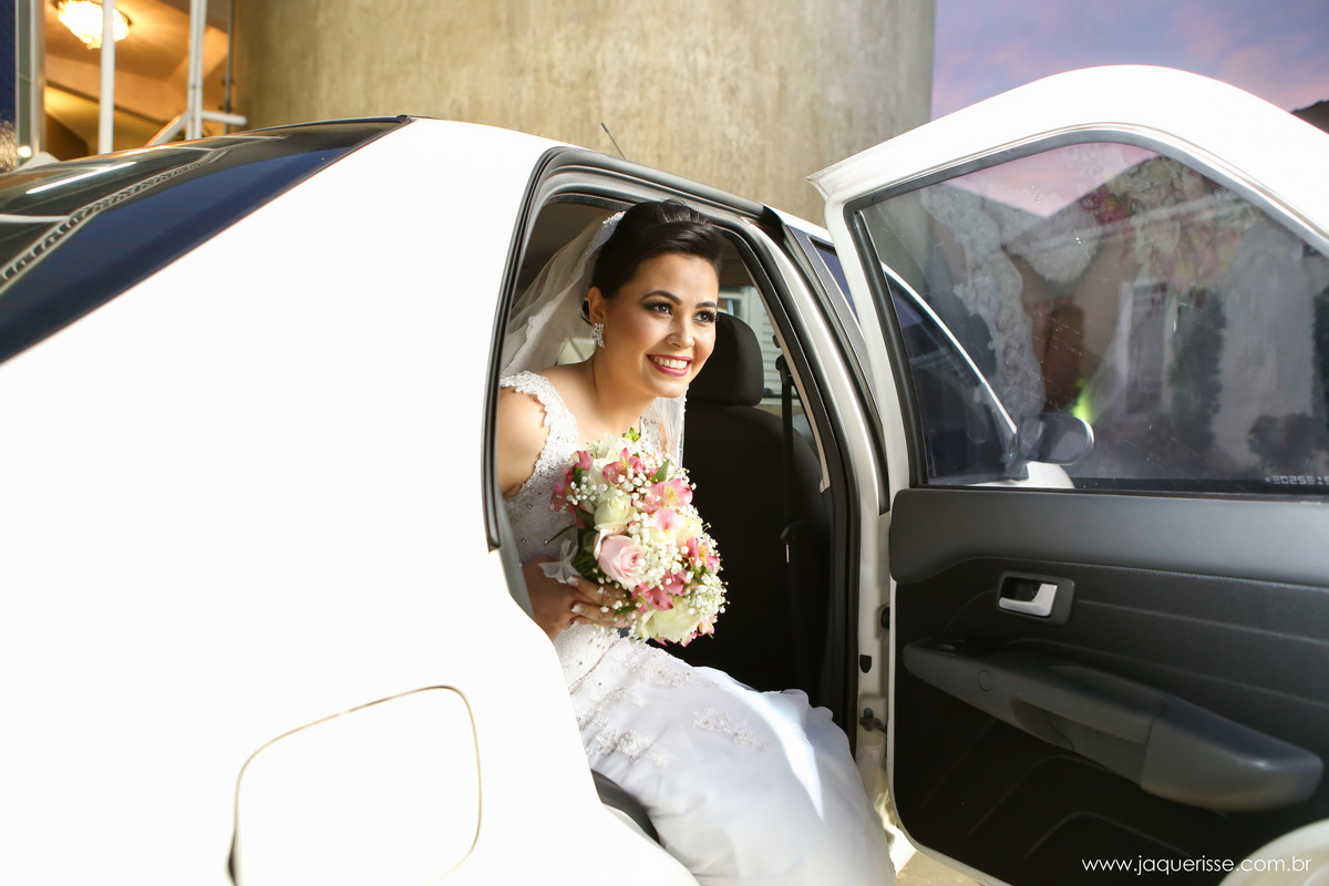 jaque risse, andre risse, estudio bebedouro, melhores fotografos, noiva sentada na beirada do banco do carro, sorrindo com seu buque na mao.