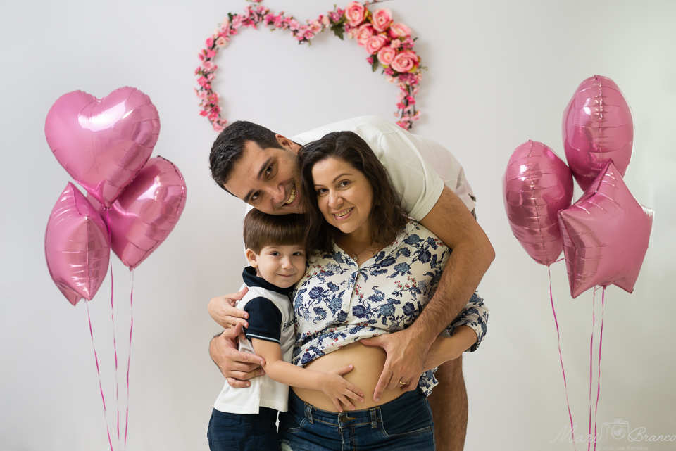 Fotografia da Família abraçando a barriguinha com o futuro bebê para anuncio de gravidez