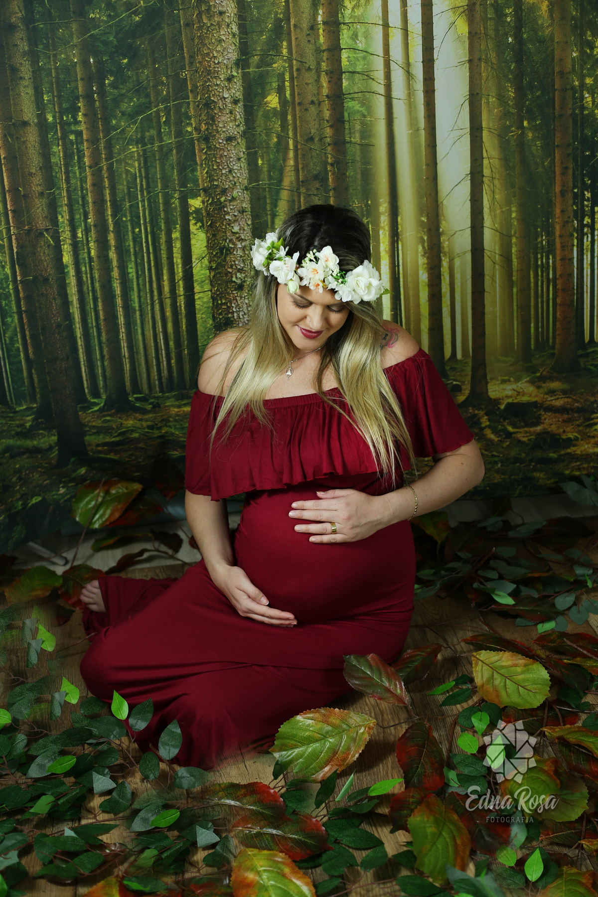 ensaio gravida 29 semanas segurando a barriga sentada no chao olhando para a barriga