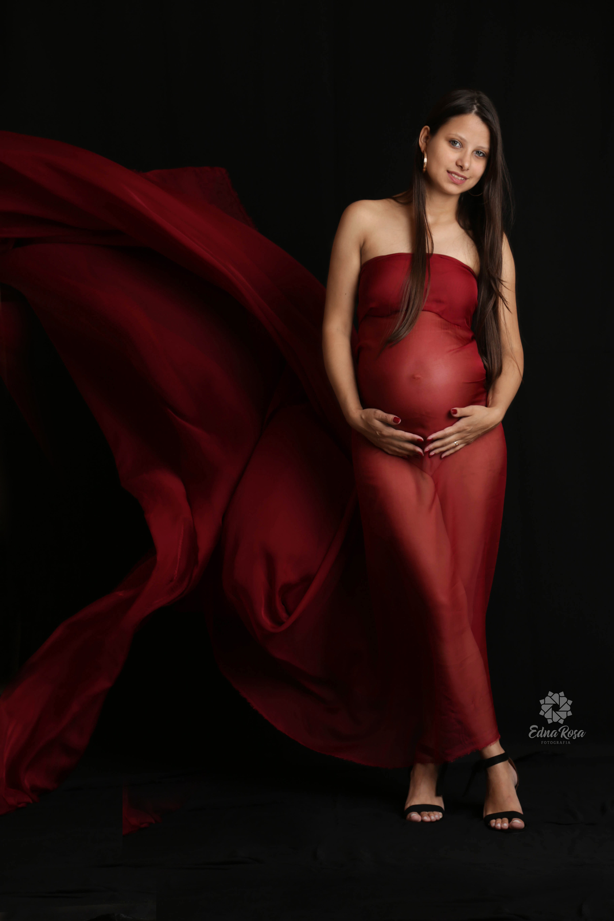 Foto de gravida usando tecido vermelho com cauda esvoaçante 