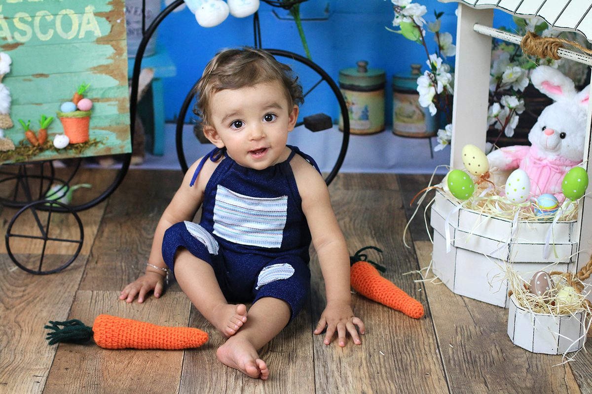 Mini sessão de páscoa com bebê usando macacão azul.