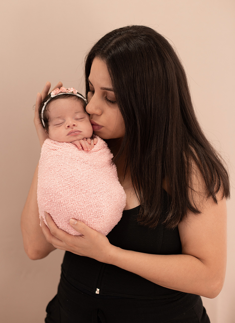 Fotografia da mãe segurando o bebê e beijando seu rostinho. no Bairro Pinheiros São Paulo SP