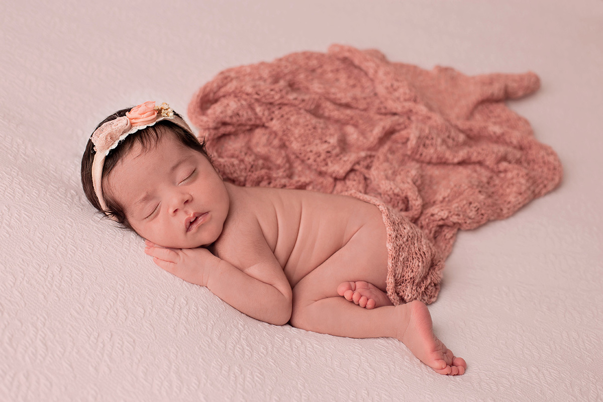 Book de fotos newborn, bebê dormindo deitado de bruços no  puff. Usando tiara na cabeça no Bairro Pinheiros São Paulo SP 