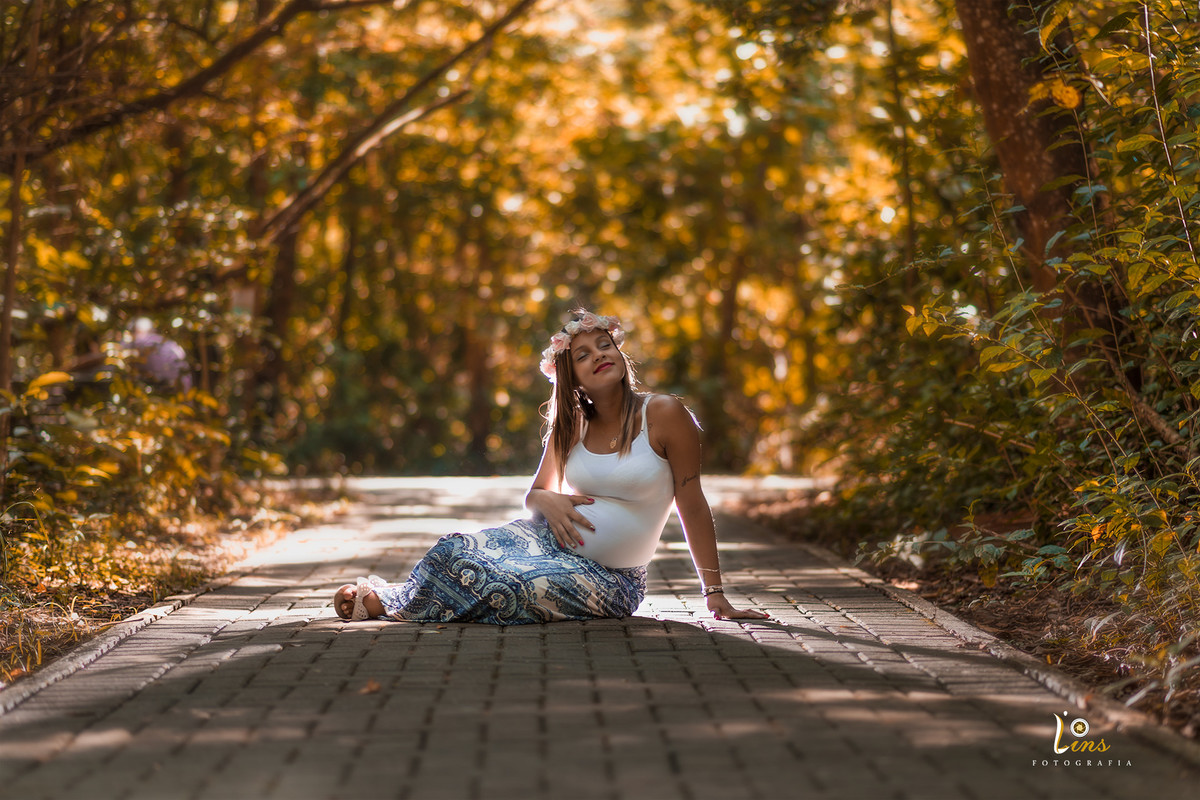 noiva gestante fazendo carinho na barriga em parque