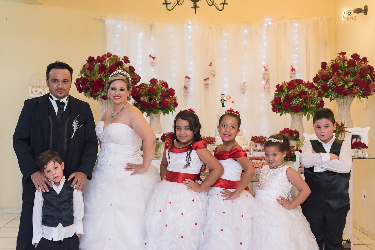 casal e meninas na frente do bolo