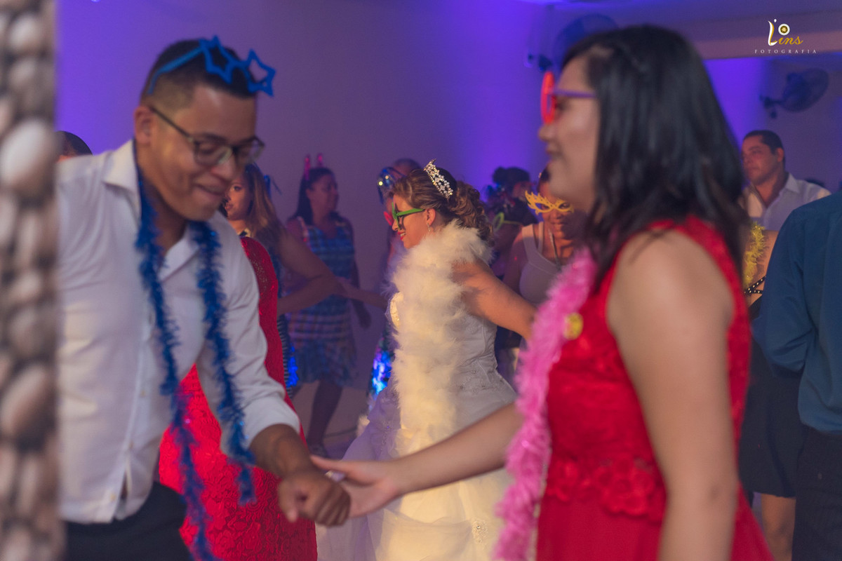 padrinhos dançando e noiva passando de fundo