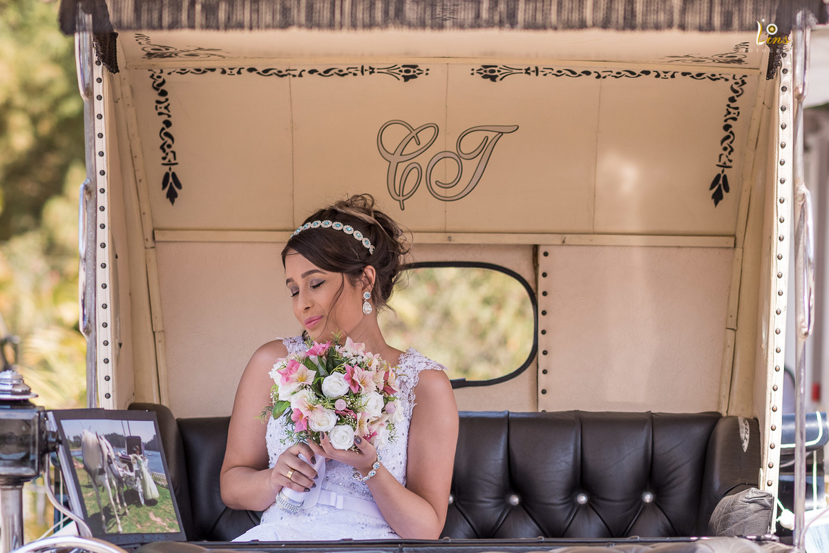 noiva posando com boque dentro de carruagem